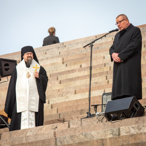 Haminan piispa Sergei kuuntelemassa ja odottamassa puhevuoroaan evankelisluterilaisen kirkon piispa emeritus Eero Huovisen puheen aikana Tuomiokirkon portailla. Kuva: Jouni Nieminen. 