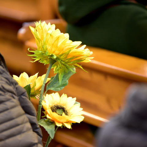 Nainen piti kirkossa käsissään auringonkukkia. Niitä pidetään Ukrainan symbolina. 