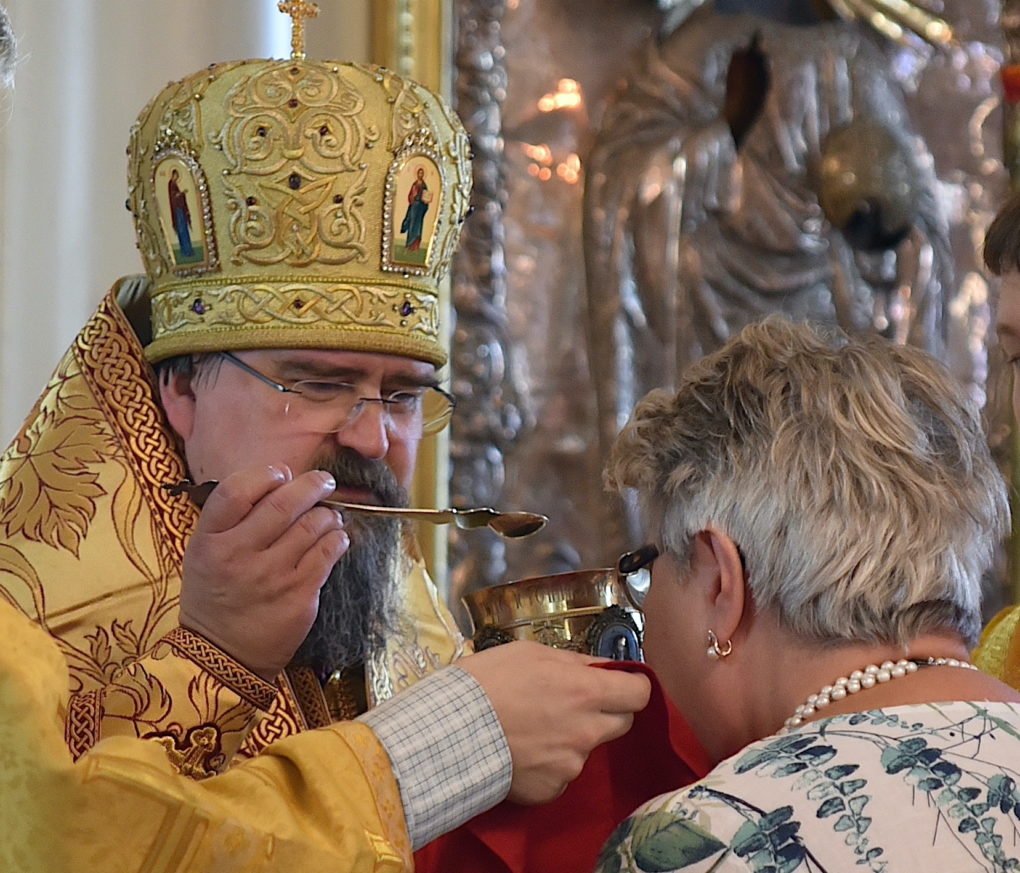 Haminan piispa Sergei jakamassa ehtoollista seurakunnan 195-vuotisjuhlaliturgian yhteydessä Pyhän Kolminaisuuden kirkossa.